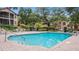 Community pool with brick patio and surrounding landscaping at 102 Camino Real Blvd # 102, Howey In The Hills, FL 34737