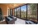 Relaxing screened porch with wicker furniture and view of lush landscape at 102 Camino Real Blvd # 102, Howey In The Hills, FL 34737