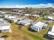 Aerial view of a 55+ community featuring numerous homes and lush green spaces at 1026 Capella Dr, Tavares, FL 32778