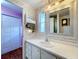Clean bathroom with white vanity and a large mirror at 1026 Capella Dr, Tavares, FL 32778