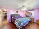 Spacious primary bedroom with a king-size bed and purple comforter at 1026 Capella Dr, Tavares, FL 32778