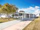 White single-story home with carport and landscaped yard at 1026 Capella Dr, Tavares, FL 32778