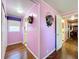 Long hallway with light purple walls and hardwood floors at 1026 Capella Dr, Tavares, FL 32778