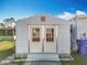 White storage shed with double doors in the backyard at 1026 Capella Dr, Tavares, FL 32778