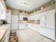 Modern kitchen featuring white cabinetry, stainless steel appliances, and tile floors at 1054 Soledad Way, The Villages, FL 32159