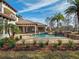 Stunning outdoor space featuring a sparkling pool, covered patio, and stone fireplace at 15118 Pendio Dr, Bella Collina, FL 34756