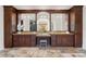 Elegant bathroom featuring granite counters, dual sinks, and beautiful brown wood cabinets and trim at 15118 Pendio Dr, Bella Collina, FL 34756