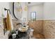 Bathroom features stone floor, stone accent wall, vessel sink, granite counter, dark fixtures, and pendant lights at 15118 Pendio Dr, Bella Collina, FL 34756