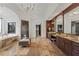 Bathroom featuring tile floors, dark wood cabinets, a soaking tub, and a large mirror at 15118 Pendio Dr, Bella Collina, FL 34756