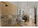 Elegant bathroom featuring a tiled shower, stone accents, and a custom vanity at 15118 Pendio Dr, Bella Collina, FL 34756