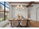 Bright dining room features exposed wood beams, statement lighting, and a large window view at 15118 Pendio Dr, Bella Collina, FL 34756