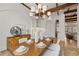 Dining room with exposed beams, modern chandelier, and decorative furnishings at 15118 Pendio Dr, Bella Collina, FL 34756
