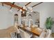 Elegant dining room showcasing exposed wood beams, stylish lighting, and open archways at 15118 Pendio Dr, Bella Collina, FL 34756