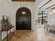 Grand foyer with an arched front door, stone floors, and elegant chandelier at 15118 Pendio Dr, Bella Collina, FL 34756