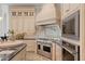 Gourmet kitchen featuring a stainless steel range, custom hood, and light-colored cabinetry at 15118 Pendio Dr, Bella Collina, FL 34756