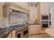 An elegant kitchen featuring a stainless steel range, custom hood, and light-colored cabinetry at 15118 Pendio Dr, Bella Collina, FL 34756