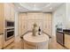 Spacious kitchen featuring a large center island with a round wooden inlay, and appliances at 15118 Pendio Dr, Bella Collina, FL 34756