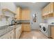 Bright laundry room offers ample storage and counter space with modern appliances at 15118 Pendio Dr, Bella Collina, FL 34756