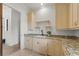 Bright laundry room featuring granite countertops, custom cabinets, and stylish fixtures at 15118 Pendio Dr, Bella Collina, FL 34756