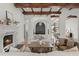Inviting living room with exposed beam ceiling, grand archways, and a cozy fireplace at 15118 Pendio Dr, Bella Collina, FL 34756