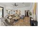 Open-concept living room featuring brick floors, a sectional sofa, and a view into the kitchen at 15118 Pendio Dr, Bella Collina, FL 34756