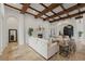 Spacious living room with wood beam ceiling, stone floors, fireplace, and views to other parts of the home at 15118 Pendio Dr, Bella Collina, FL 34756