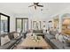 Bright living room with a large grey sectional couch, modern decor, and view to the pool at 15118 Pendio Dr, Bella Collina, FL 34756