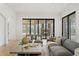 Living room featuring large sectional, stylish seating, and large sliding glass doors to the outdoor area at 15118 Pendio Dr, Bella Collina, FL 34756