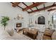 Bright living area with travertine floors, wood beam ceiling, and a cozy fireplace at 15118 Pendio Dr, Bella Collina, FL 34756