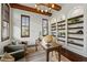 Bright office includes coffered wood beam ceiling, dark wood floors, and custom built-in bookshelves at 15118 Pendio Dr, Bella Collina, FL 34756
