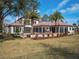 Expansive backyard featuring a custom home with a screened patio, outdoor fireplace and mature landscaping at 15118 Pendio Dr, Bella Collina, FL 34756