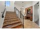 Beautiful staircase with stone floors, wooden treads, and iron railing at 15118 Pendio Dr, Bella Collina, FL 34756