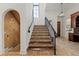 Beautiful staircase with stone floors, wooden treads, and iron railing at 15118 Pendio Dr, Bella Collina, FL 34756