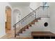 Beautiful staircase with stone floors, wooden treads, and iron railing at 15118 Pendio Dr, Bella Collina, FL 34756