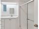 Simple bathroom with white vanity, a mirror and a shower at 16 Captains Pt, Fruitland Park, FL 34731
