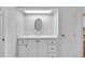 Simple bathroom with white vanity and oval mirror at 16 Captains Pt, Fruitland Park, FL 34731
