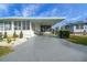 Landscaped manufactured home with covered carport at 16 Captains Pt, Fruitland Park, FL 34731