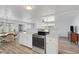 Modern kitchen with white cabinets, stainless steel appliances, and vinyl flooring at 16 Captains Pt, Fruitland Park, FL 34731