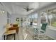 Bright sunroom with rocking chairs, a couch, and a ceiling fan at 16 Captains Pt, Fruitland Park, FL 34731