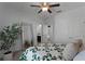 Bedroom features a ceiling fan, carpet, neutral paint, closet doors, and an adjacent bathroom at 16428 Good Hearth Blvd, Clermont, FL 34711