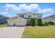 Two-story home featuring a three-car garage, manicured lawn, and neatly trimmed shrubs at 16428 Good Hearth Blvd, Clermont, FL 34711
