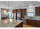 Kitchen features granite countertops, stainless steel appliances, dark wood cabinets, and an island with barstool seating at 16428 Good Hearth Blvd, Clermont, FL 34711