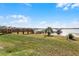 Peaceful lake view with a wooden deck and grassy area at 16428 Good Hearth Blvd, Clermont, FL 34711