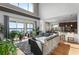 Bright living room boasts a lake view through sliding glass doors, hardwood floors, and a large grey sectional sofa at 16428 Good Hearth Blvd, Clermont, FL 34711