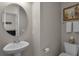 This powder room features a pedestal sink, toilet, framed mirror, neutral paint, and a towel rack at 16428 Good Hearth Blvd, Clermont, FL 34711
