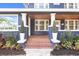 Inviting front porch with brick steps, white columns, and stylish planters at 2001 Sanford Ave, Sanford, FL 32771
