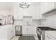 Modern white kitchen with stainless steel appliances and marble backsplash at 2001 Sanford Ave, Sanford, FL 32771
