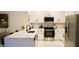 Modern kitchen features stainless steel appliances, white cabinetry, and a breakfast bar with seating at 2295 Delhi Pl, Sanford, FL 32771