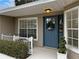 Charming front entrance with a blue door and wreath at 25141 Clifford Hl, Leesburg, FL 34748