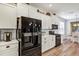 Modern kitchen with white cabinets and black appliances at 26633 Otter Creek Ln, Leesburg, FL 34748